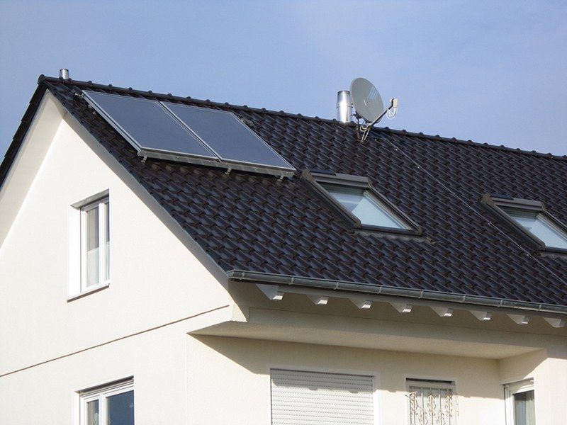 HB Holzbau Breymaier GmbH –
Sicht auf eine Dachschräge mit neuen Dachschindeln und Solarpanel