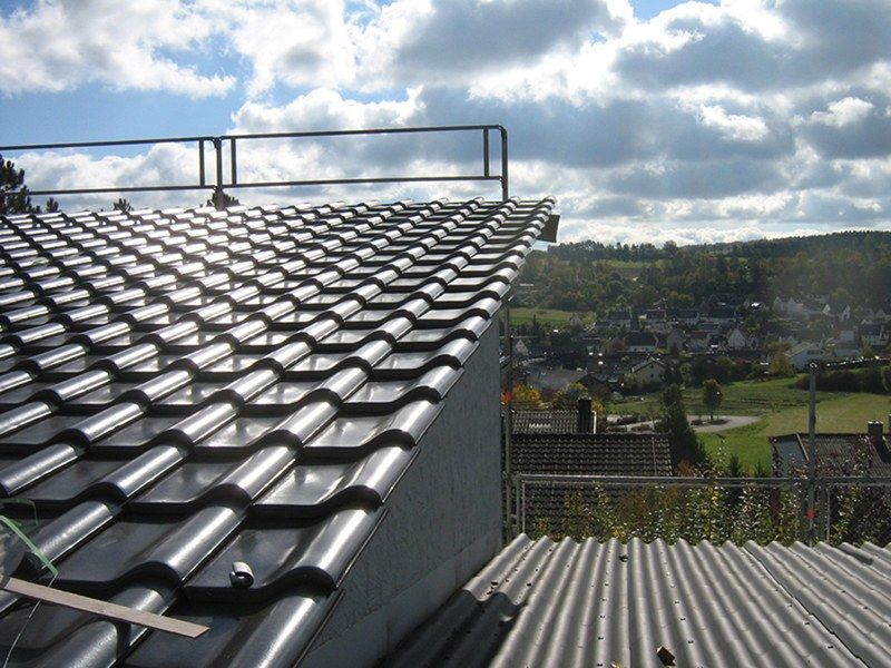 HB Holzbau Breymaier GmbH – 
Nahaufnahme von Dachschindeln nach Installation, mit Dachfenster