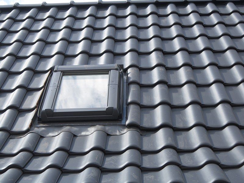 HB Holzbau Breymaier GmbH – 
Nahaufnahme von Dachschindeln nach Installation, mit Dachfenster