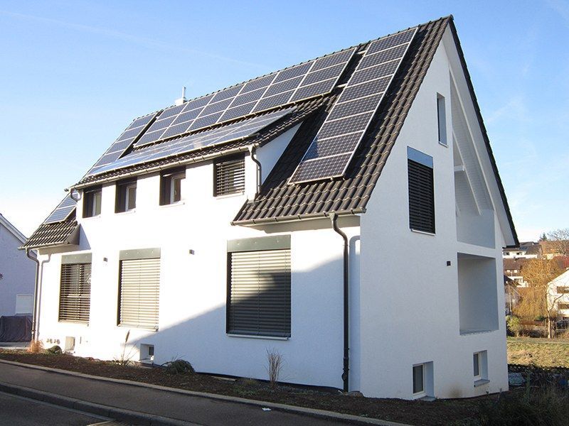 HB Holzbau Breymaier GmbH –
Weißes Haus mit Solarpaneelen auf dem Schrägdach