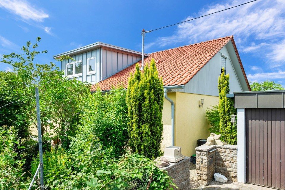 HB Holzbau Breymaier GmbH – Wohnhaus hinter Bäumen mit Schrägdach und Dachausbau