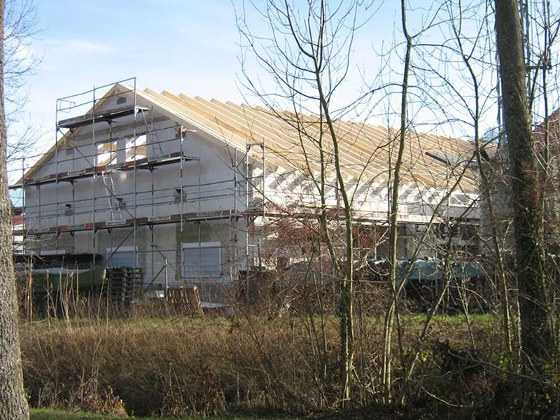 HB Holzbau Breymaier GmbH – Hausfassade mit Baugerüsten bis zum Dach