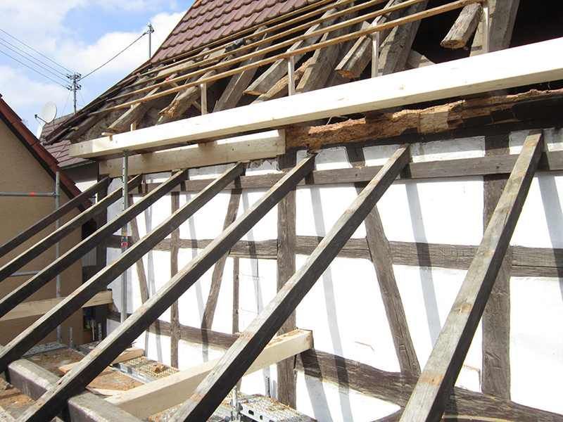 HB Holzbau Breymaier GmbH – Blick auf schräge Holzbalken während einer Neubedachung