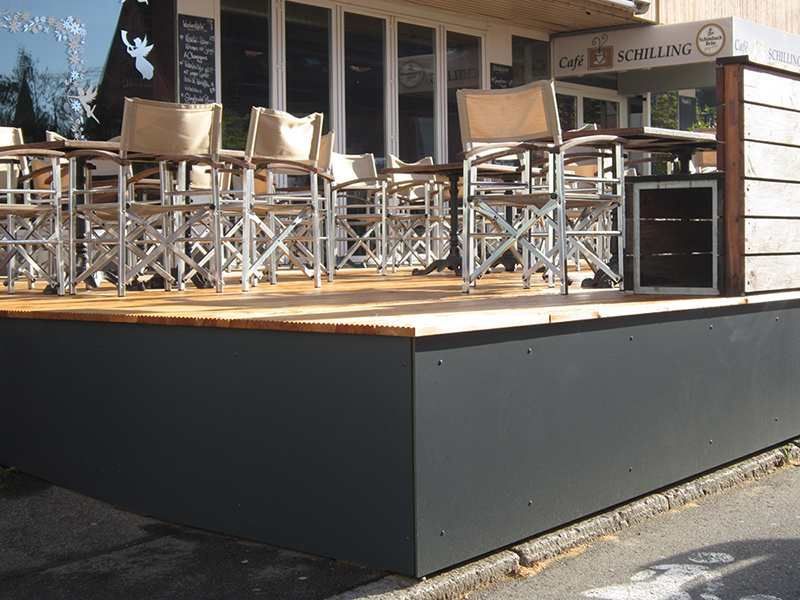 HB Holzbau Breymaier GmbH – Erhöhter Terassenbereich mit Sitzmöglichkeiten und schwarzer Seitenverkleidung