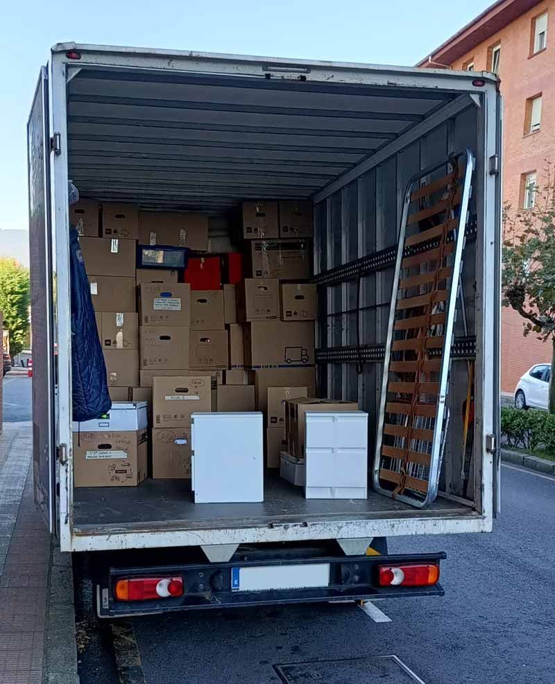 La parte trasera de un camión lleno de cajas y un marco de cama.