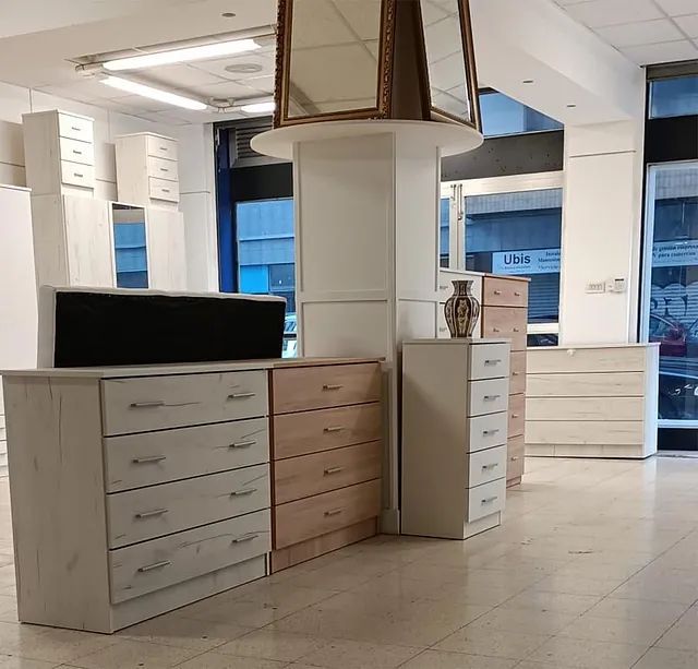 Una habitación con muchos cajones y un espejo colgando del techo.