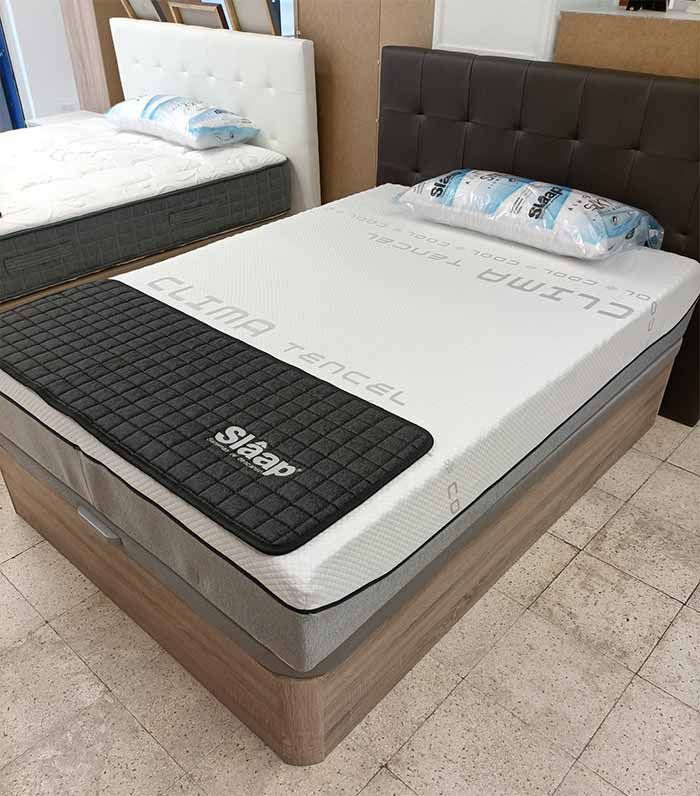 Una cama con un colchón y almohadas encima en una tienda.