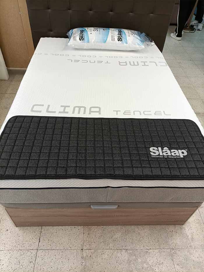 Una cama con un colchón y almohadas encima.
