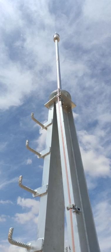 Una estructura metálica muy alta con un cielo azul de fondo.