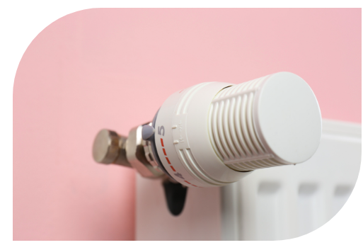 Un primer plano de un termostato blanco sobre una pared rosa.
