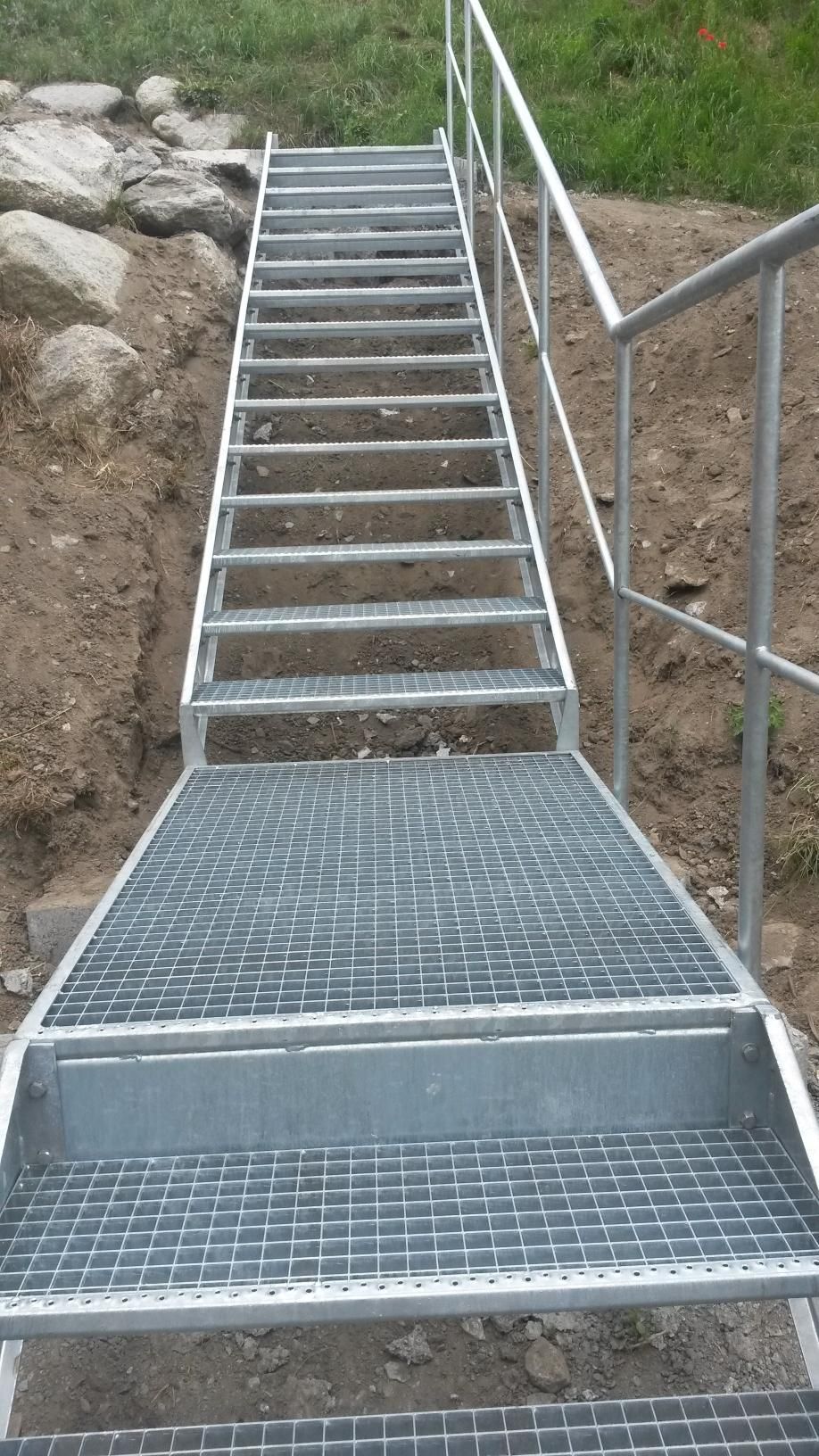 Un escalier métallique avec une rampe métallique.
