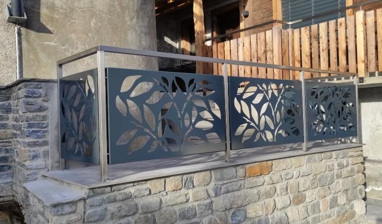 Une balustrade en métal avec des feuilles découpées.
