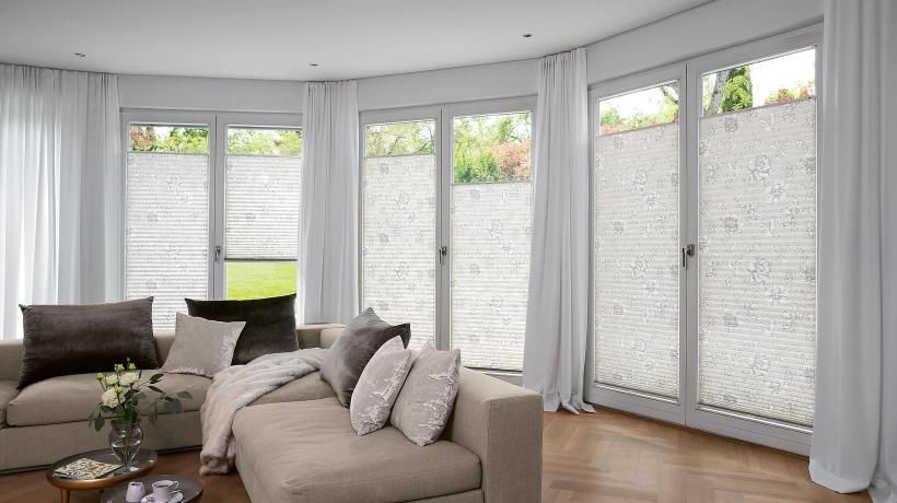 Un salon avec un canapé , des rideaux et des portes coulissantes en verre.