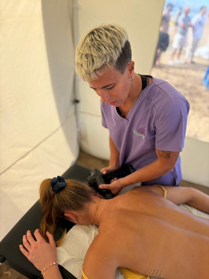El médico ayuda al paciente con ejercicios con mancuernas para la terapia del brazo.