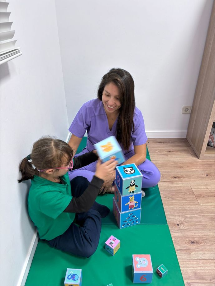 Un profesor se enfrenta a unos estudiantes sentados en sus pupitres en un aula, algunos de ellos sonrientes y comprometidos.