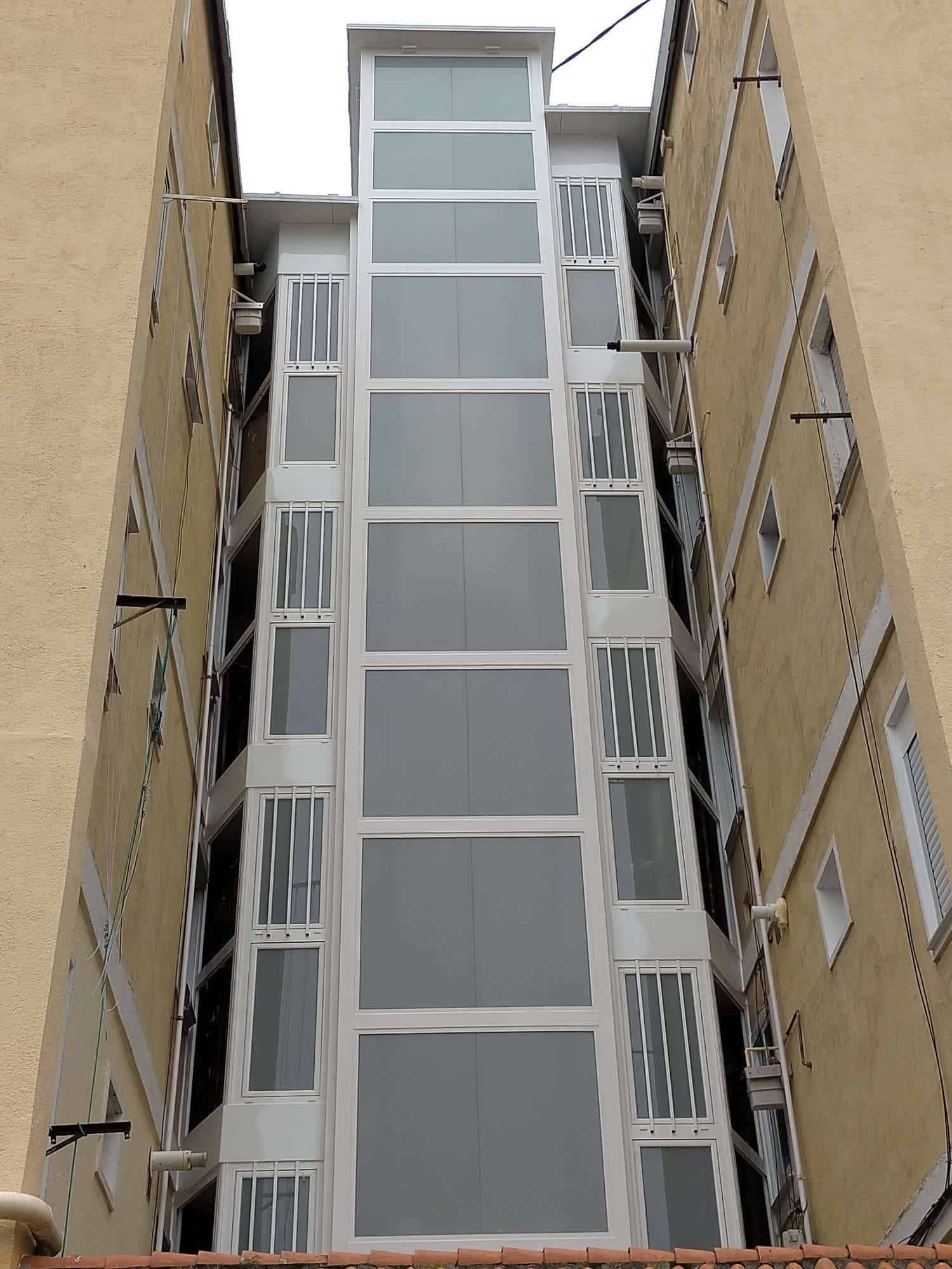 Ascensor exterior de cristal entre dos edificios.