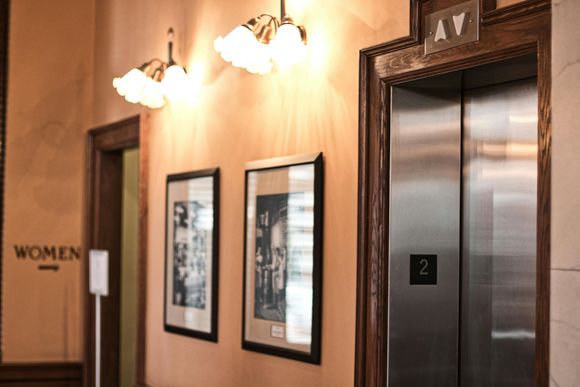 Entrada de edificio gris con puerta, panel de vidrio, portón de seguridad y número de dirección 20.