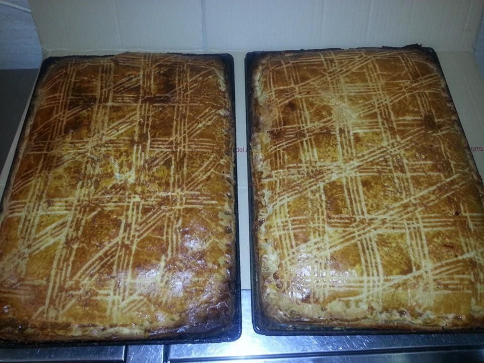 Dos bandejas de pan están colocadas encima de una estufa.