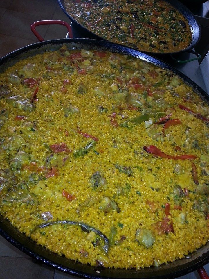 Una sartén llena de arroz y verduras está sobre una mesa.