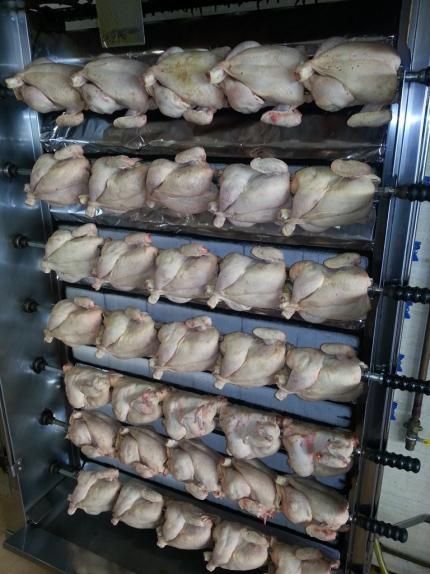 Un grupo de pollos se están cocinando en una parrilla