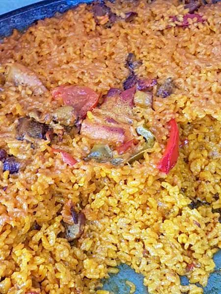 Un primer plano de una cazuela llena de arroz y verduras.