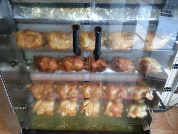 El pollo se cocina en una parrilla en un horno de acero inoxidable.