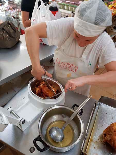 Una mujer con un delantal blanco está preparando comida.
