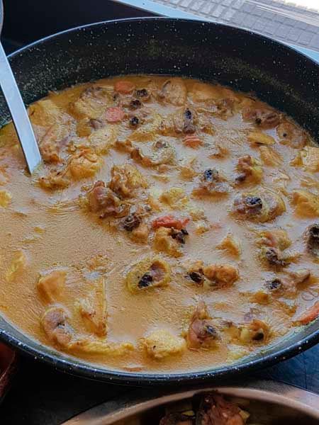 Un primer plano de un tazón de sopa con una cuchara dentro.