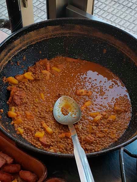 Una sartén llena de salsa y una cuchara dentro.