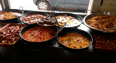 Una mesa de buffet llena de muchos tipos diferentes de comida.
