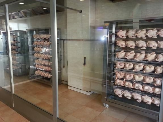 Se cocinan pollos en una vitrina en un restaurante.