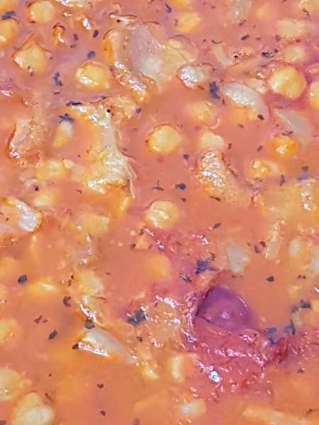 Un primer plano de una salsa de tomate con maíz y cebolla.