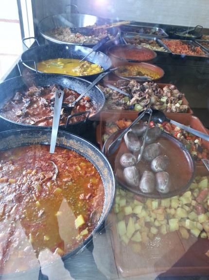 Una variedad de alimentos en sartenes con cucharas en ellas