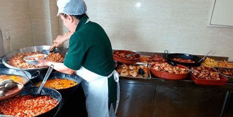 Un hombre está preparando comida en una cocina.