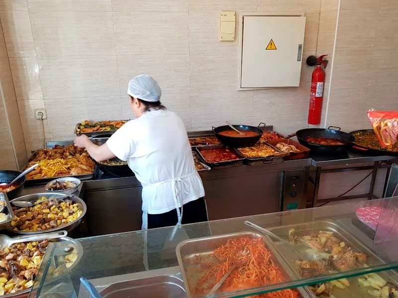 Una mujer está preparando comida en la cocina de un restaurante.