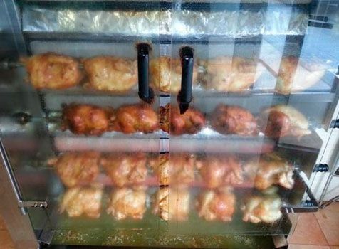 Un montón de pollos se están cocinando en un horno.