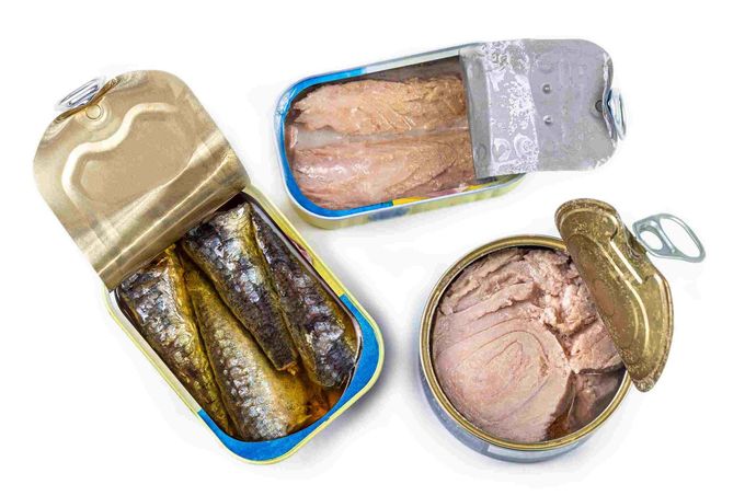 Tres latas de pescado abiertas: sardinas, atún en agua y atún en trozos.