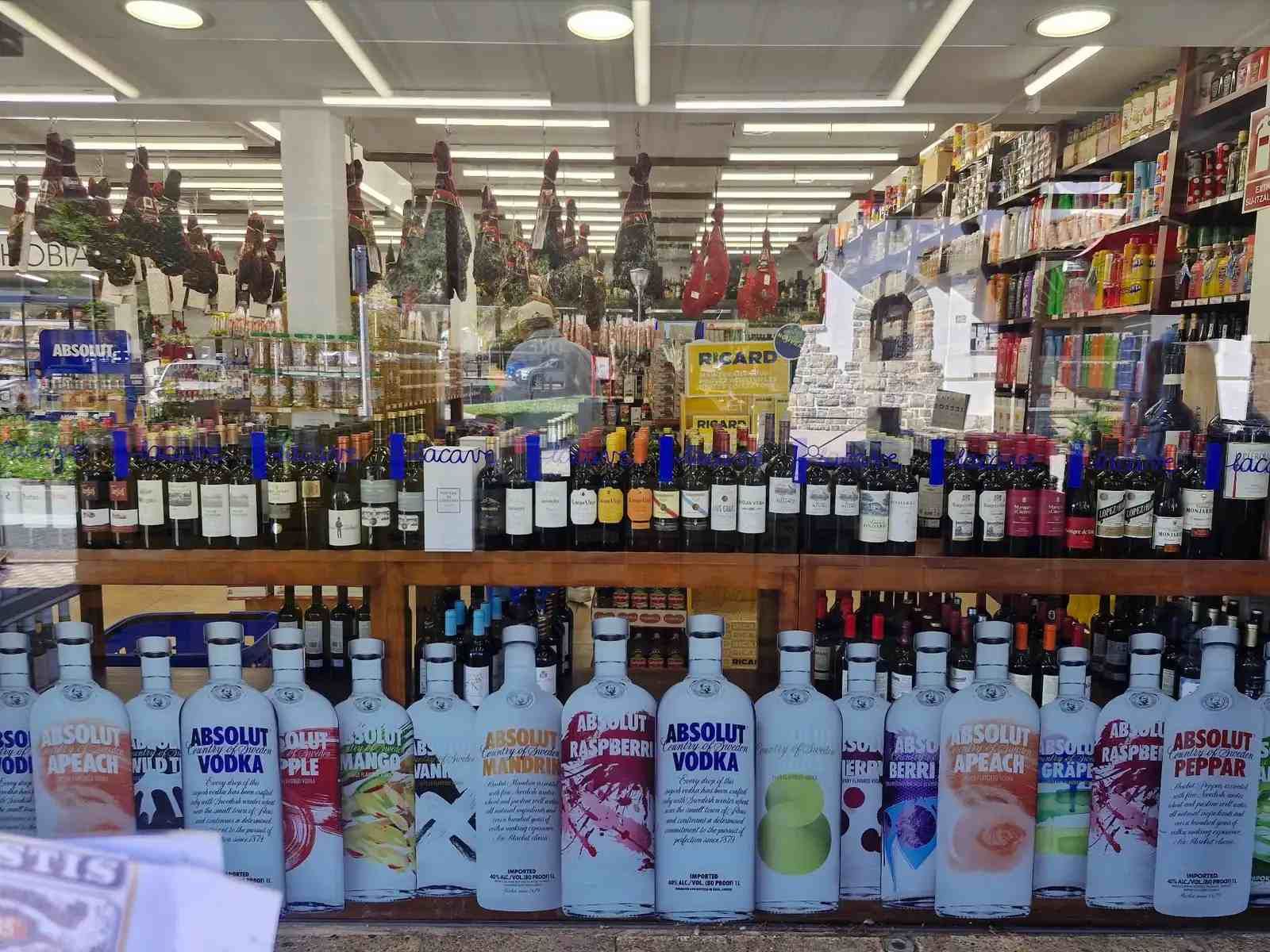 Licorería con hileras de botellas de vino y vodka.