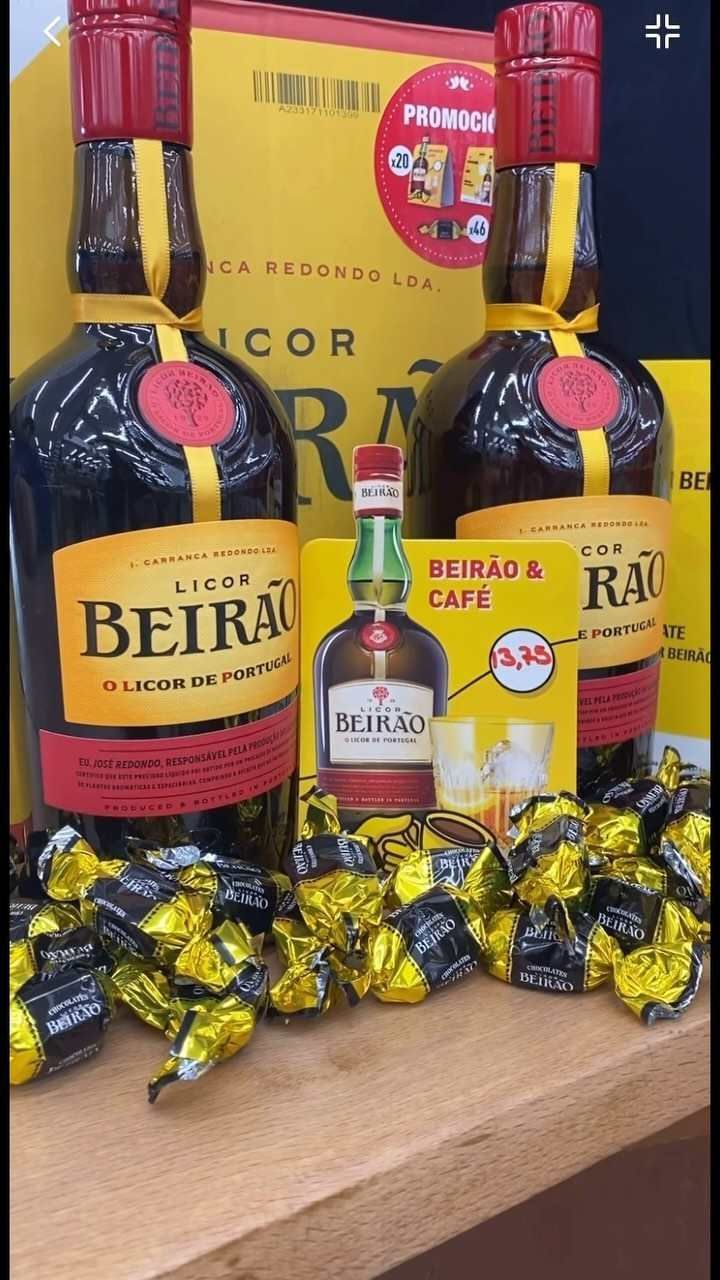Dos botellas de licor Beirão con una botella miniatura y caramelos envueltos.