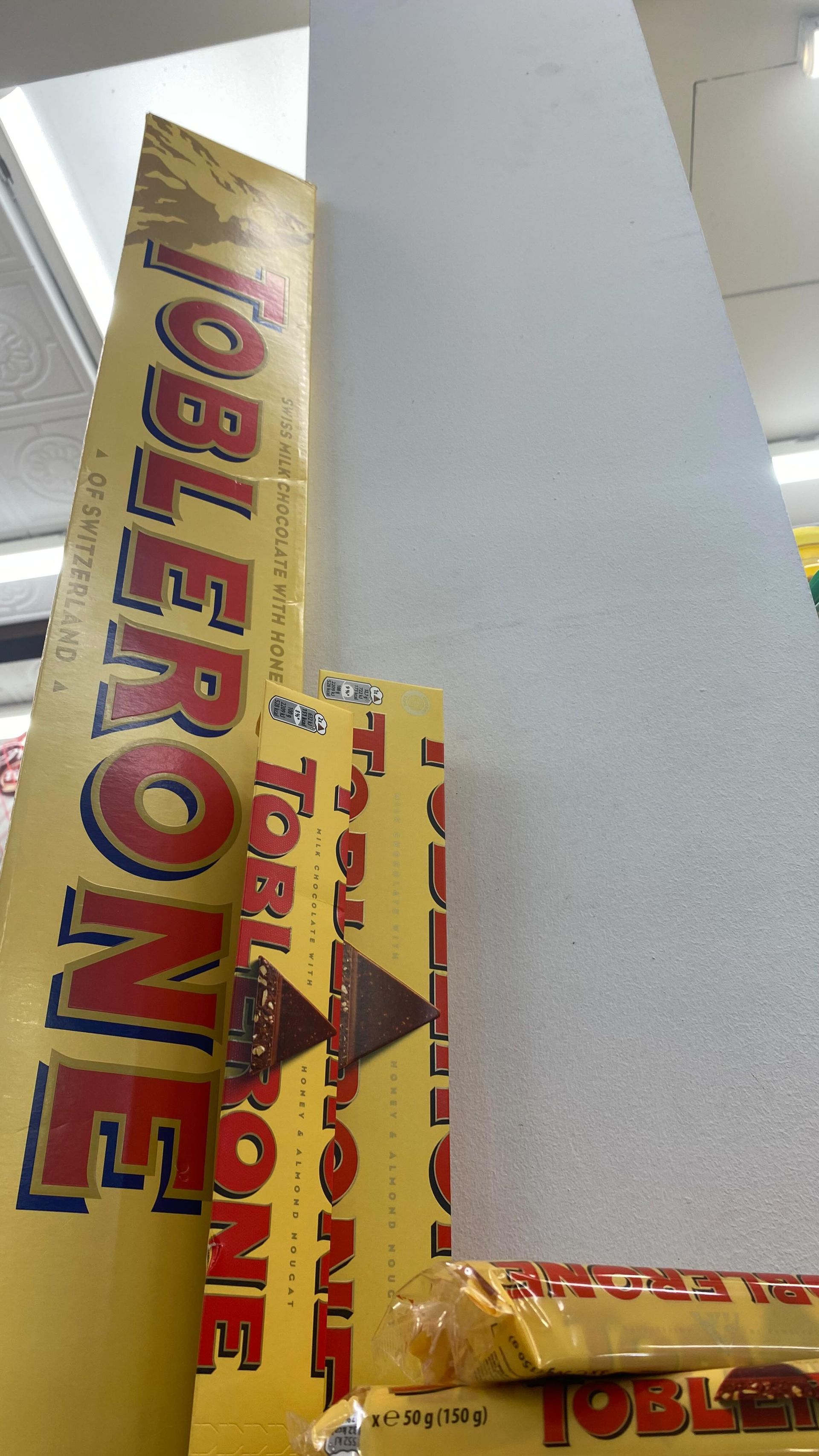 Cesta de regalo navideña rebosante de dulces, cinta y una botella de vino.