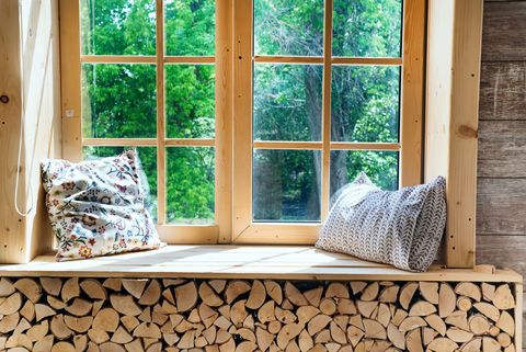 Des coussins devant une fenêtre en bois