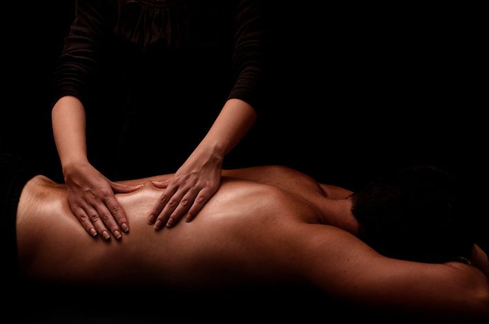 Homme allongé pour un massage. Fond de la photo noir