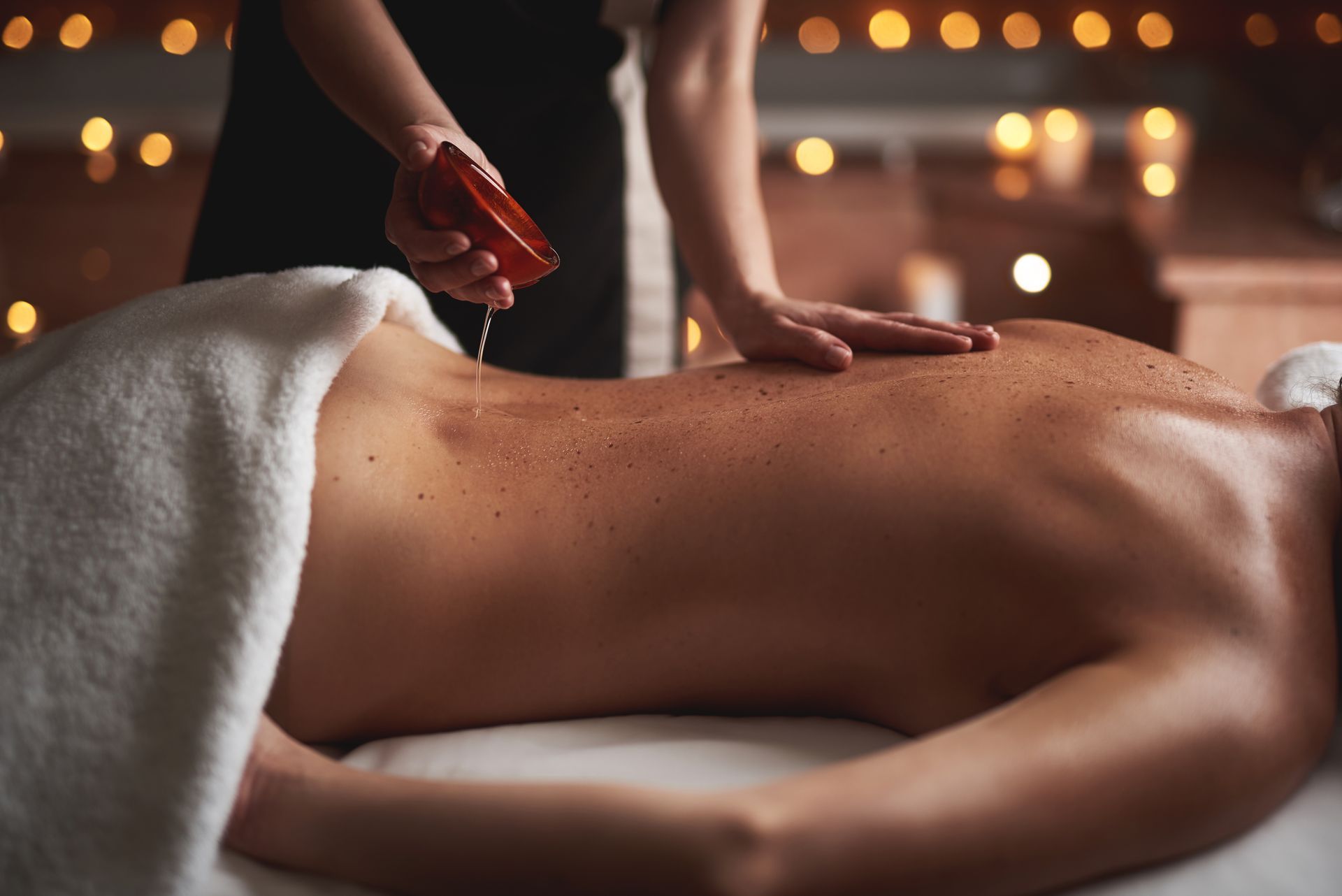 De l'huile versée sur un dos dans un salon de massage