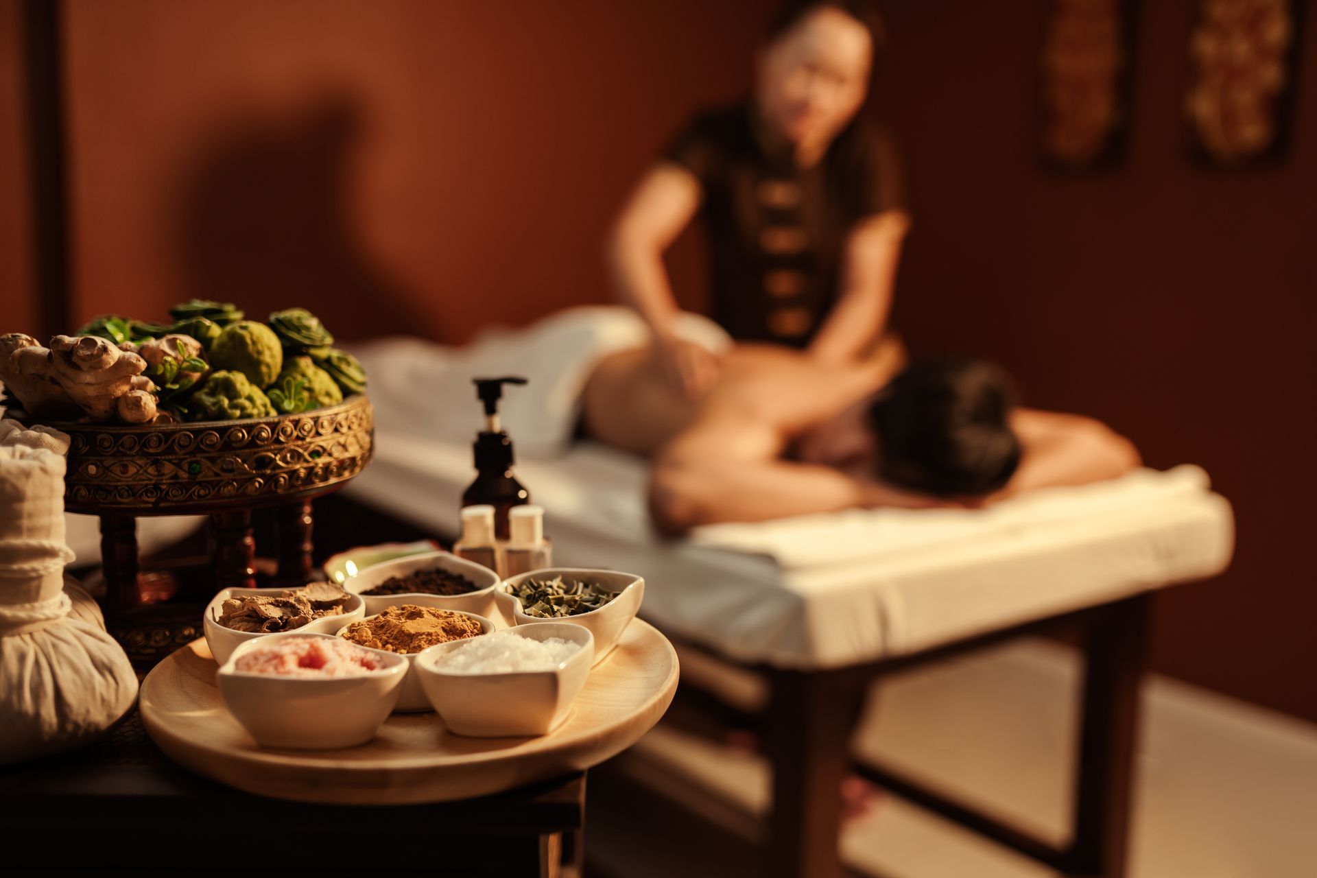 Plateau d'épices et d'huiles, et séance de massage en arrière plan