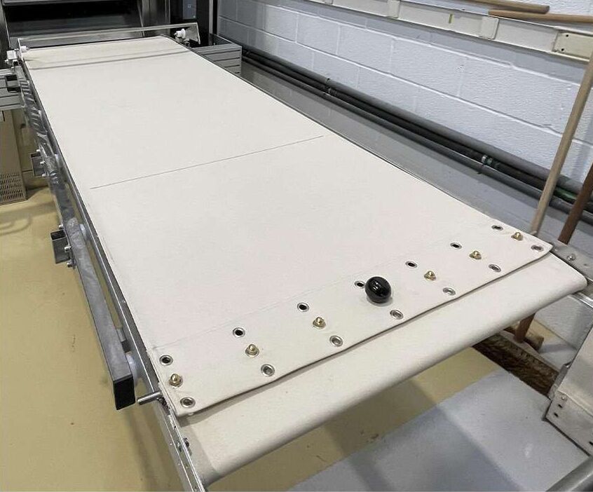 Una cinta transportadora está colocada encima de una mesa en una habitación.