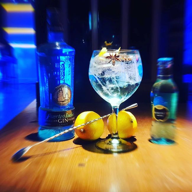 Una botella de ginebra está junto a un vaso de ginebra.