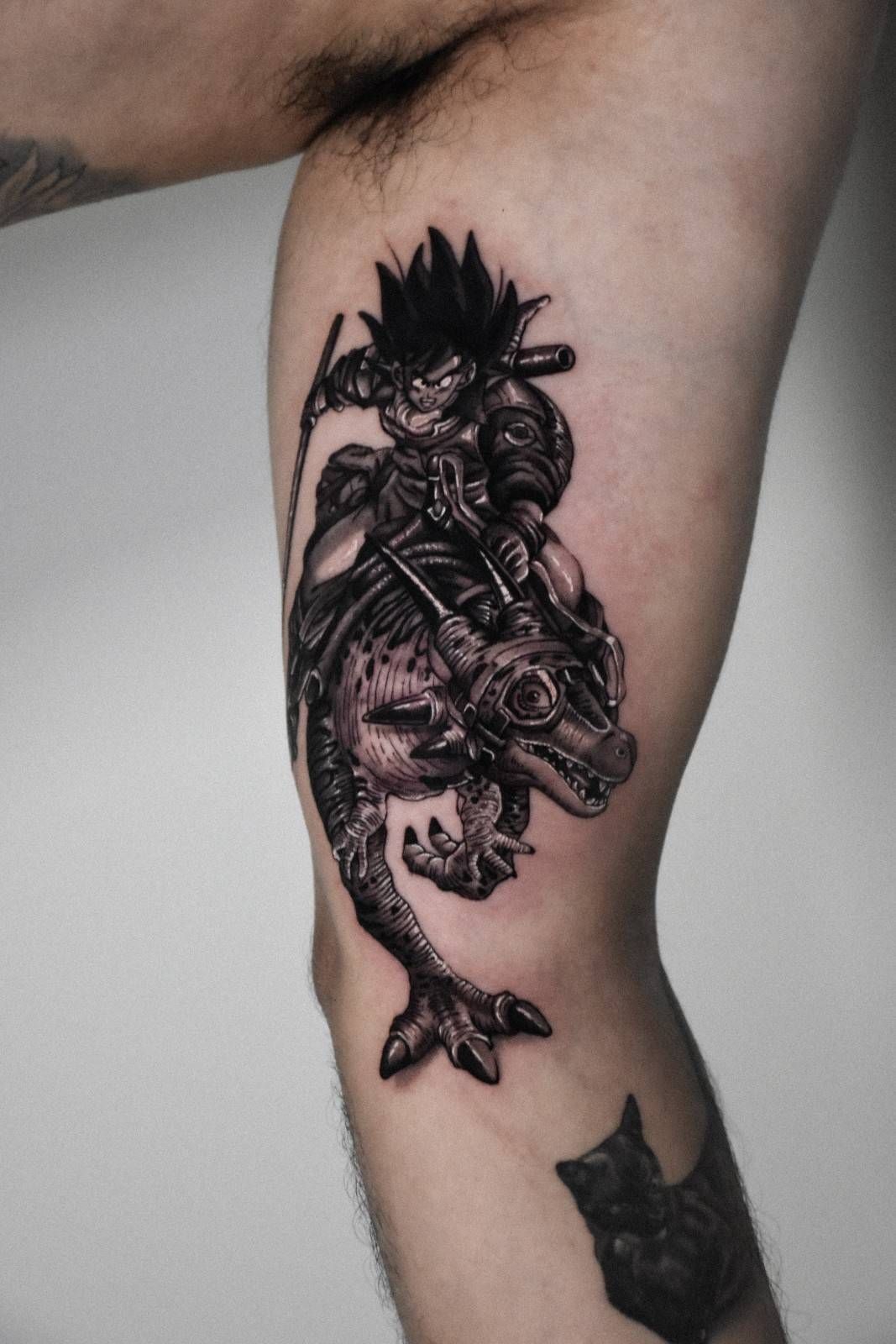 Tatuaje de un personaje cabalgando sobre una criatura parecida a un dinosaurio en la pierna. Blanco y negro, detallado.