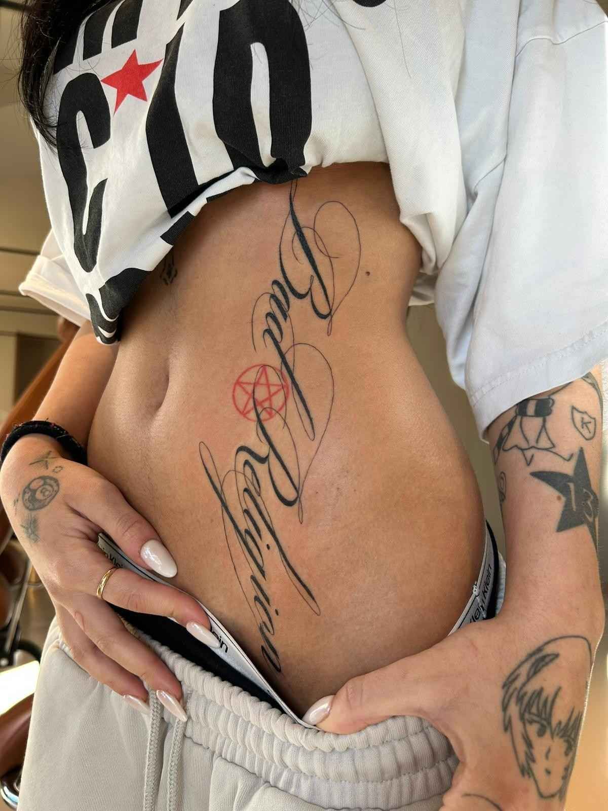 Torso de una persona con un gran tatuaje lateral que dice 