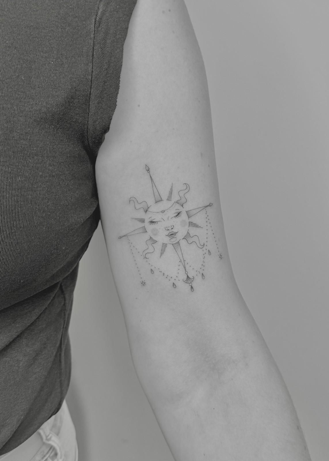 Brazo con un tatuaje detallado de rayos de sol.
