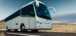 Un gran autobús blanco circula por una carretera.